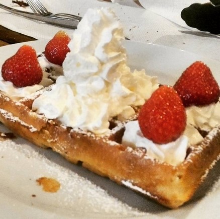 big pile of cream and strawberries on a waffle in Belgium